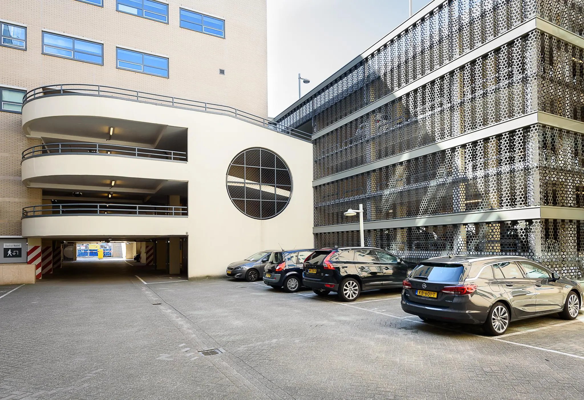 Parkeergarage aan het Daalseplein met geparkeerde auto's en zicht op moderne gevel en spiraalvormige oprit.