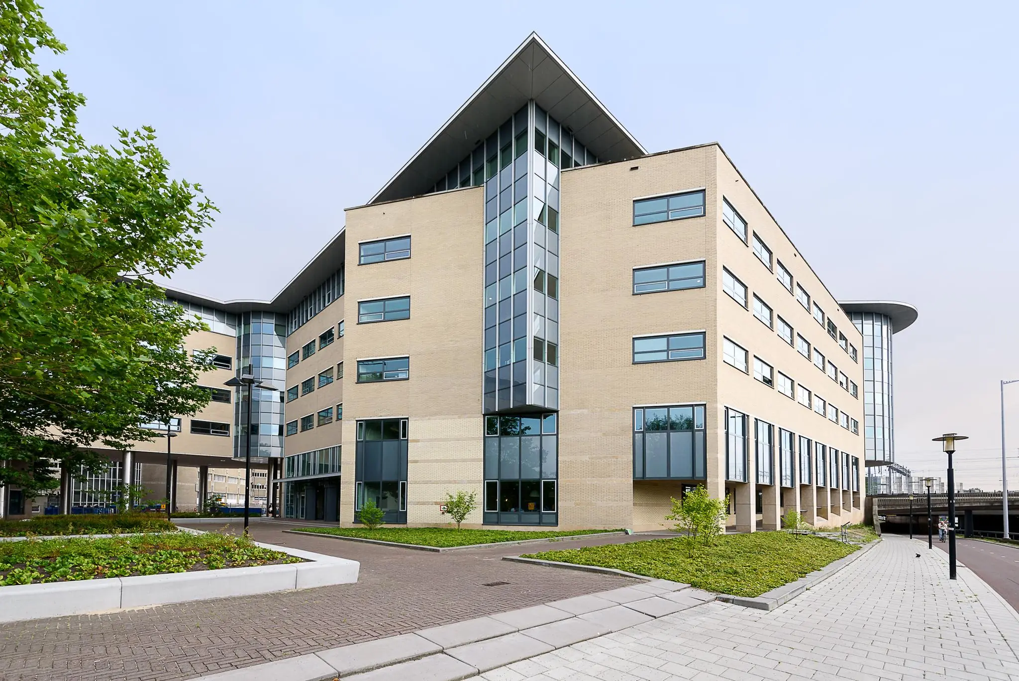 Modern kantoorgebouw aan het Daalseplein met beige gevel, grote ramen en een opvallende hoekvorm.