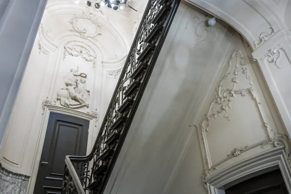 Sierlijke trap met rijk gedecoreerde stucreliëfs en klassieke beeldhouwwerken in een monumentaal pand aan de Herengracht.