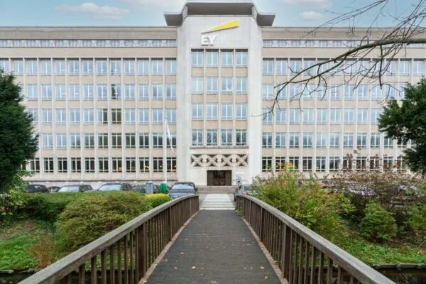 Vooraanzicht van het EY-kantoorgebouw aan de Wassenaarseweg met een brug in de voortuin.