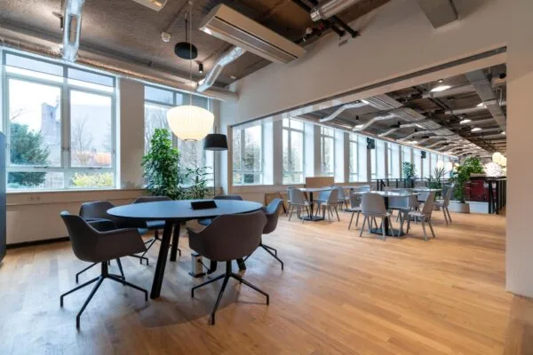 Moderne en lichte kantoorruimte aan de Wassenaarseweg met houten vloer, grote ramen en diverse zitplekken.