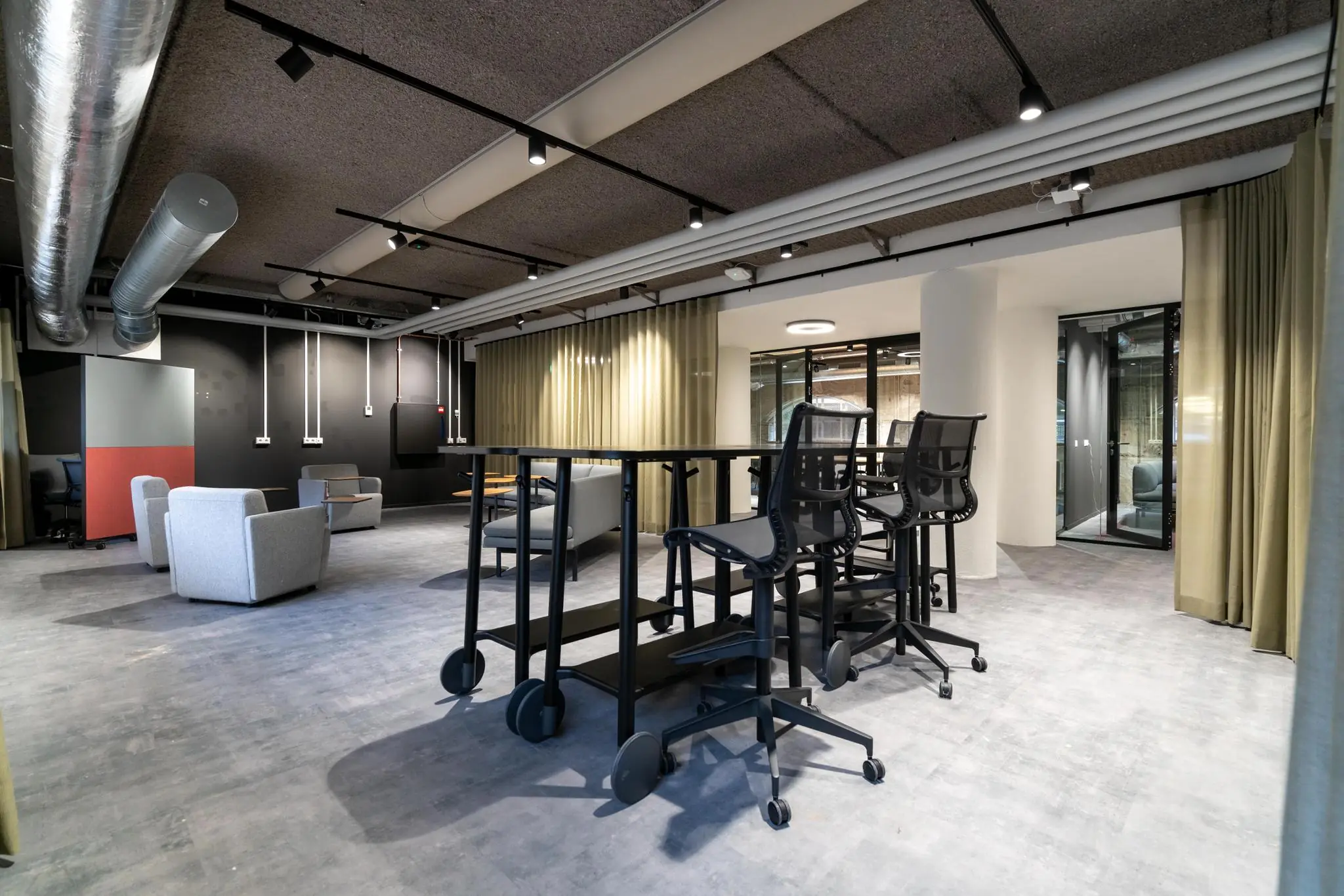 Moderne kantoorruimte aan de Wassenaarseweg met hoge tafels, bureaustoelen en loungezitjes in een open indeling.