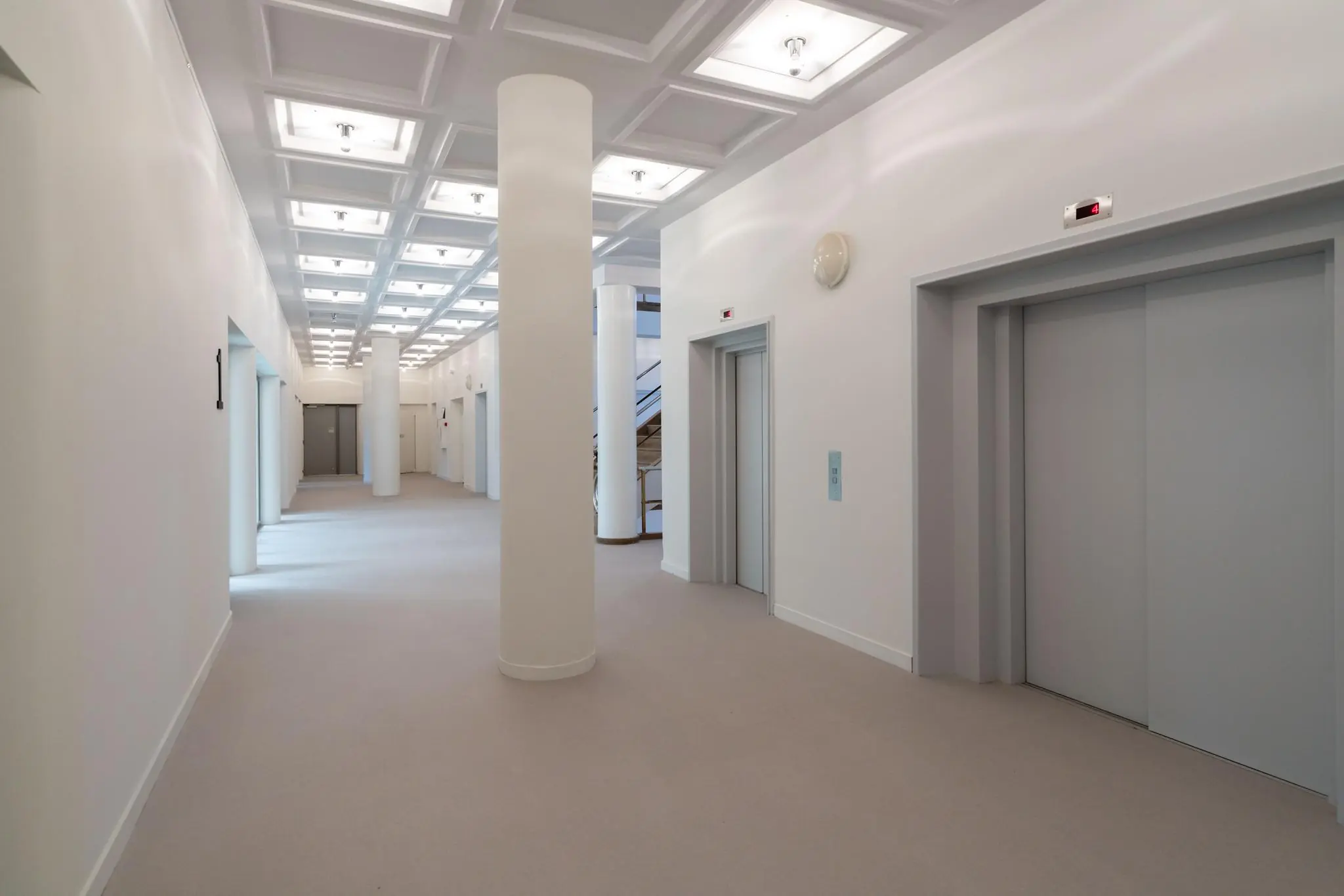Licht en ruimtelijk ganggebied met meerdere liften in een modern gebouw aan de Wassenaarseweg.