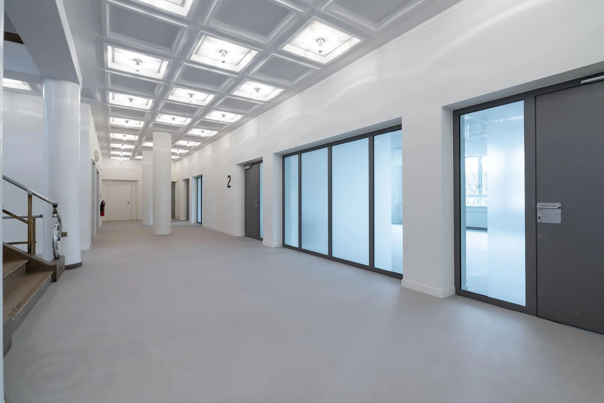 Moderne en lichte kantoorgang met glazen kantoorwanden aan de Wassenaarseweg.