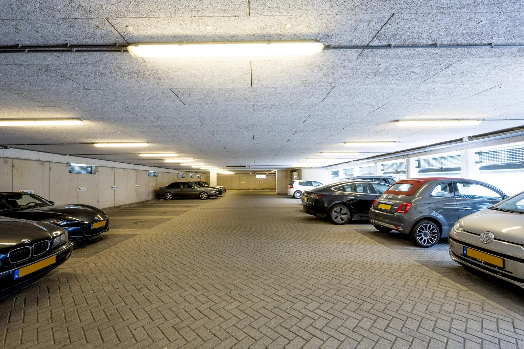 Ondergrondse parkeergarage aan de Naritaweg met geparkeerde auto's aan beide zijden.