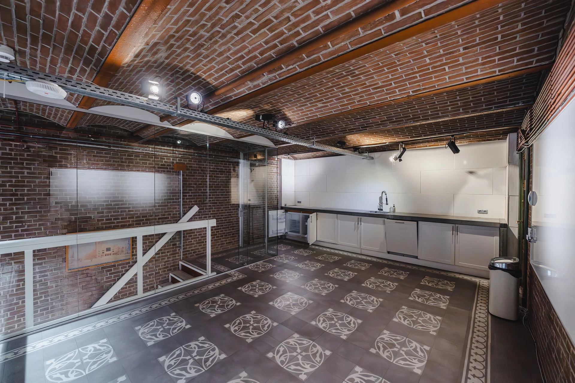 Moderne keuken in een souterrain met bakstenen muren, gewelfd plafond en decoratieve tegels op de vloer aan het Damrak.