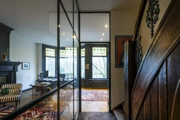 Stijlvol ingericht kantoor aan het Eerste Weteringplantsoen met glaswand, houten details en glas-in-loodramen.