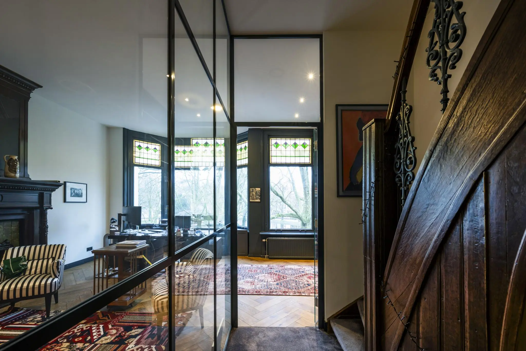 Stijlvol ingericht kantoor aan het Eerste Weteringplantsoen met glaswand, houten details en glas-in-loodramen.