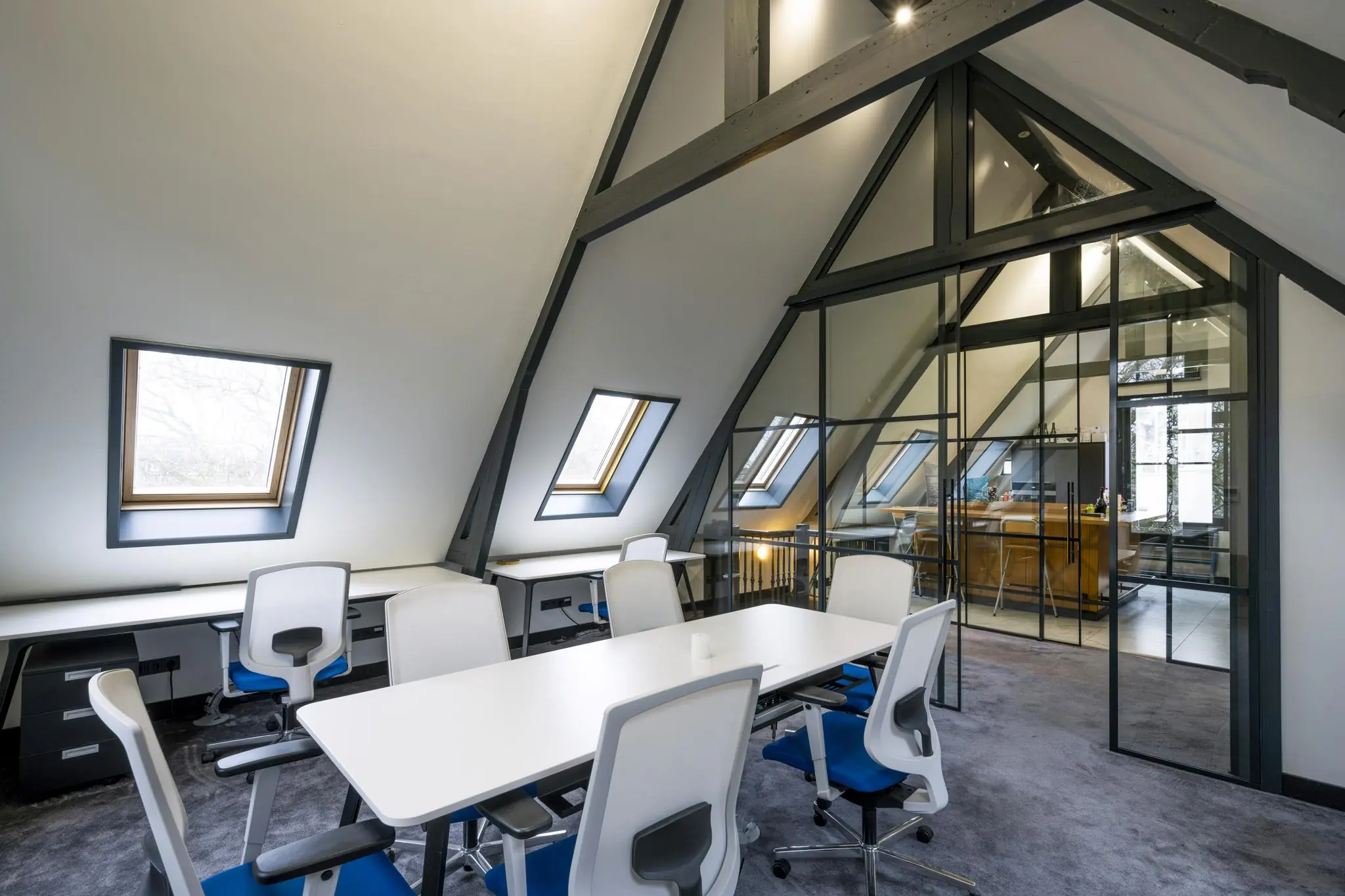 Modern kantoorinterieur in het Eerste Weteringplantsoen met schuine plafonds, dakramen en glazen scheidingswanden.