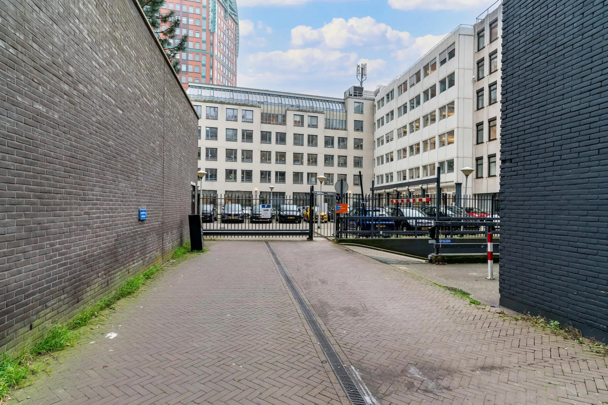 Toegangspad naar een afgesloten parkeerterrein bij een kantoorgebouw aan de Bezuidenhoutseweg in Den Haag.