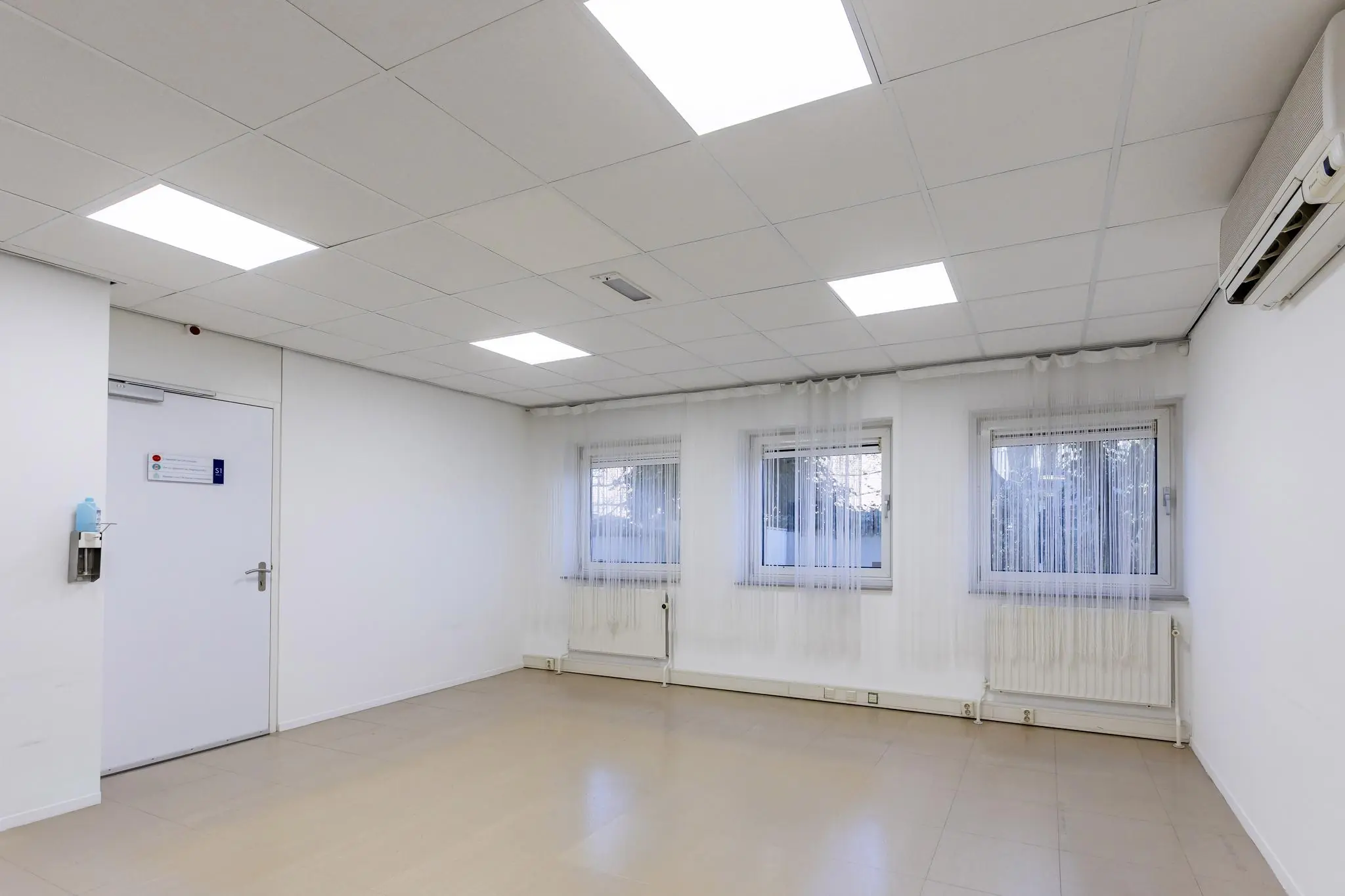 Lichte, lege kantoorruimte aan de 's-Gravenweg met drie ramen, systeemplafond en airconditioning.
