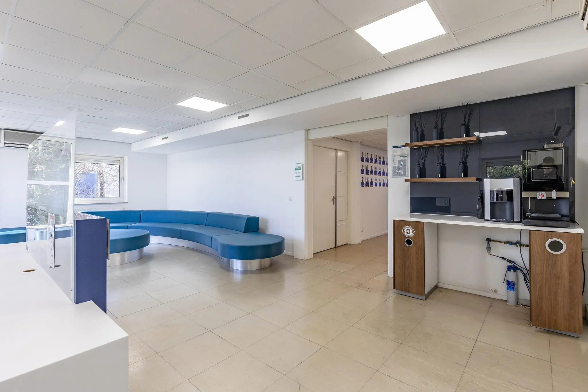 Wachtruimte met blauw ronde zithoek en koffiecorner in een modern kantoor aan de 's-Gravenweg.