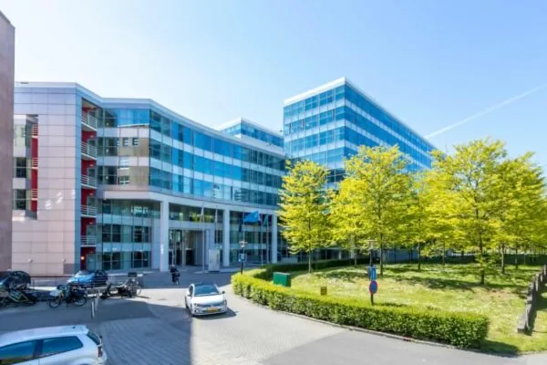 Modern kantoorgebouw aan de Newtonlaan met glazen gevels en omliggend groen.