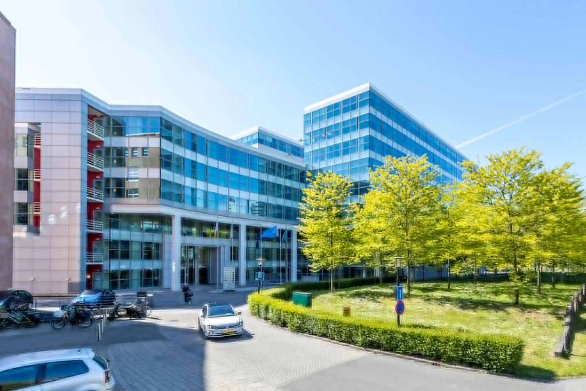 Modern kantoorgebouw aan de Newtonlaan met glazen gevels en omliggend groen.