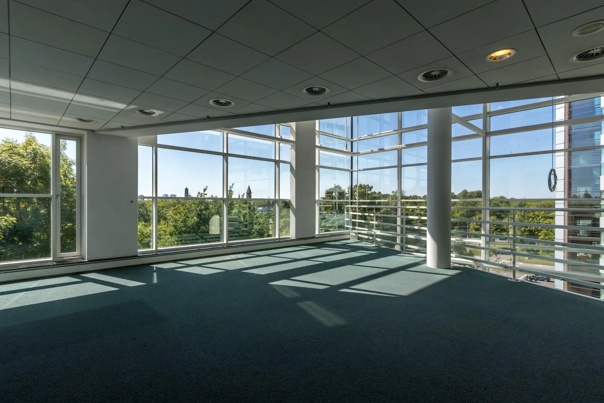 Licht en ruim hoekkantoor aan de Newtonlaan met grote ramen en uitzicht op groen.