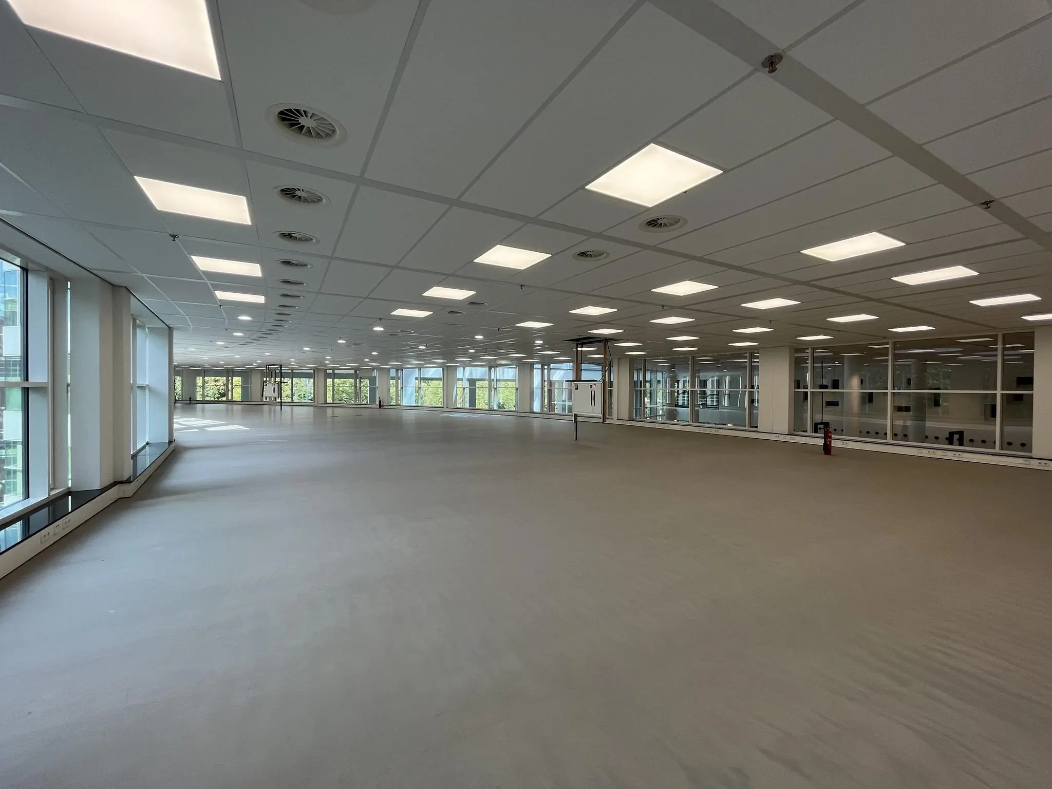 Ruime, lege kantoorverdieping aan de Newtonlaan met veel ramen en systeemplafondverlichting.