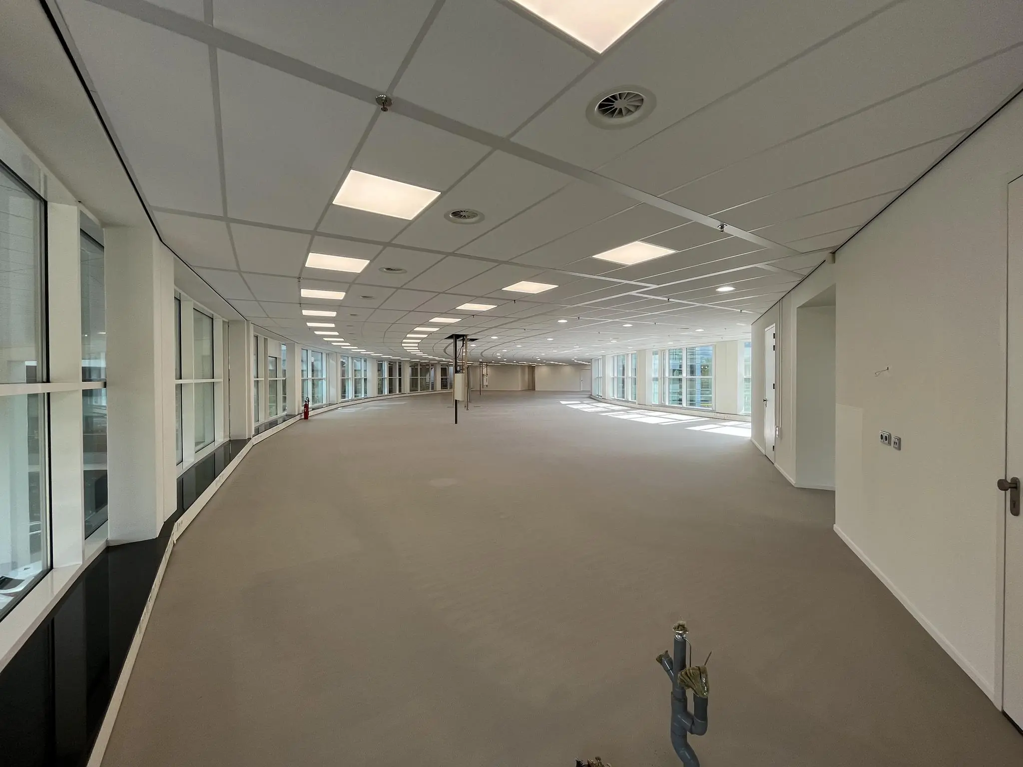 Ruime, lege kantoorruimte aan de Newtonlaan met grote ramen en systeemplafond.