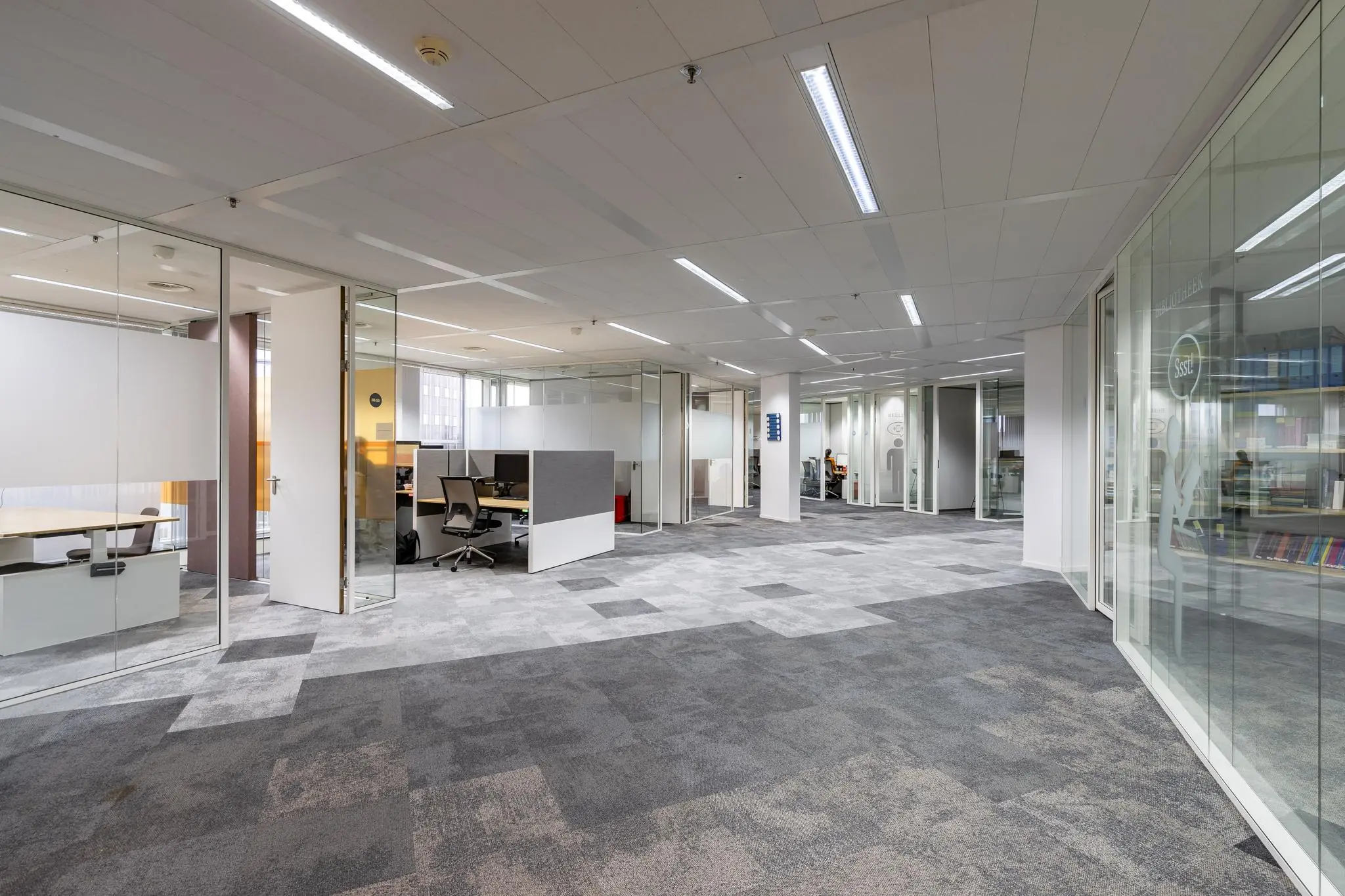 Moderne, open kantoortuin op Newtonlaan met glazen wanden, werkplekken en rustige inrichting.