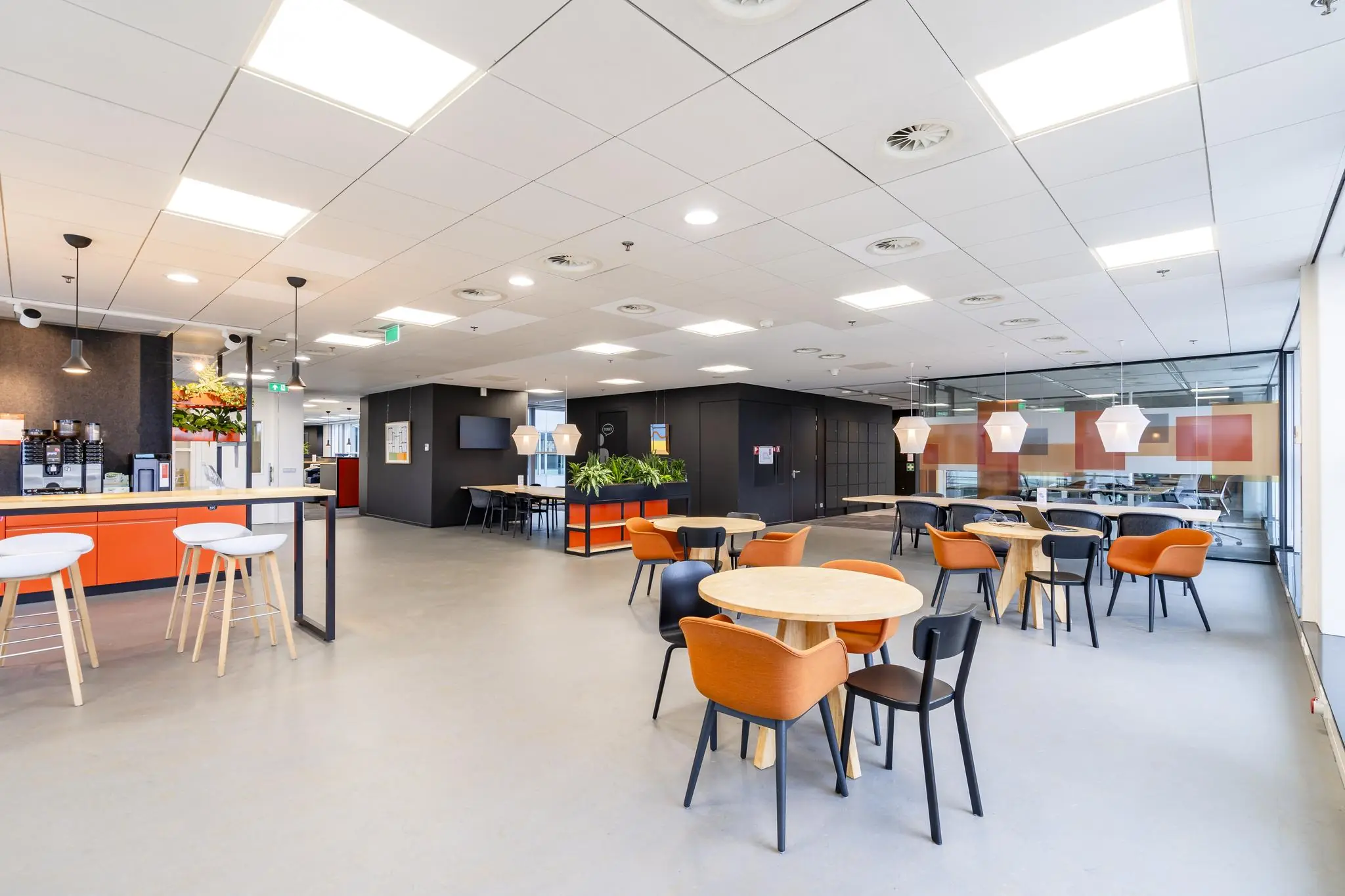 Moderne en open kantoorpauzeruimte aan de Newtonlaan met zitjes, planten en een koffiecorner.