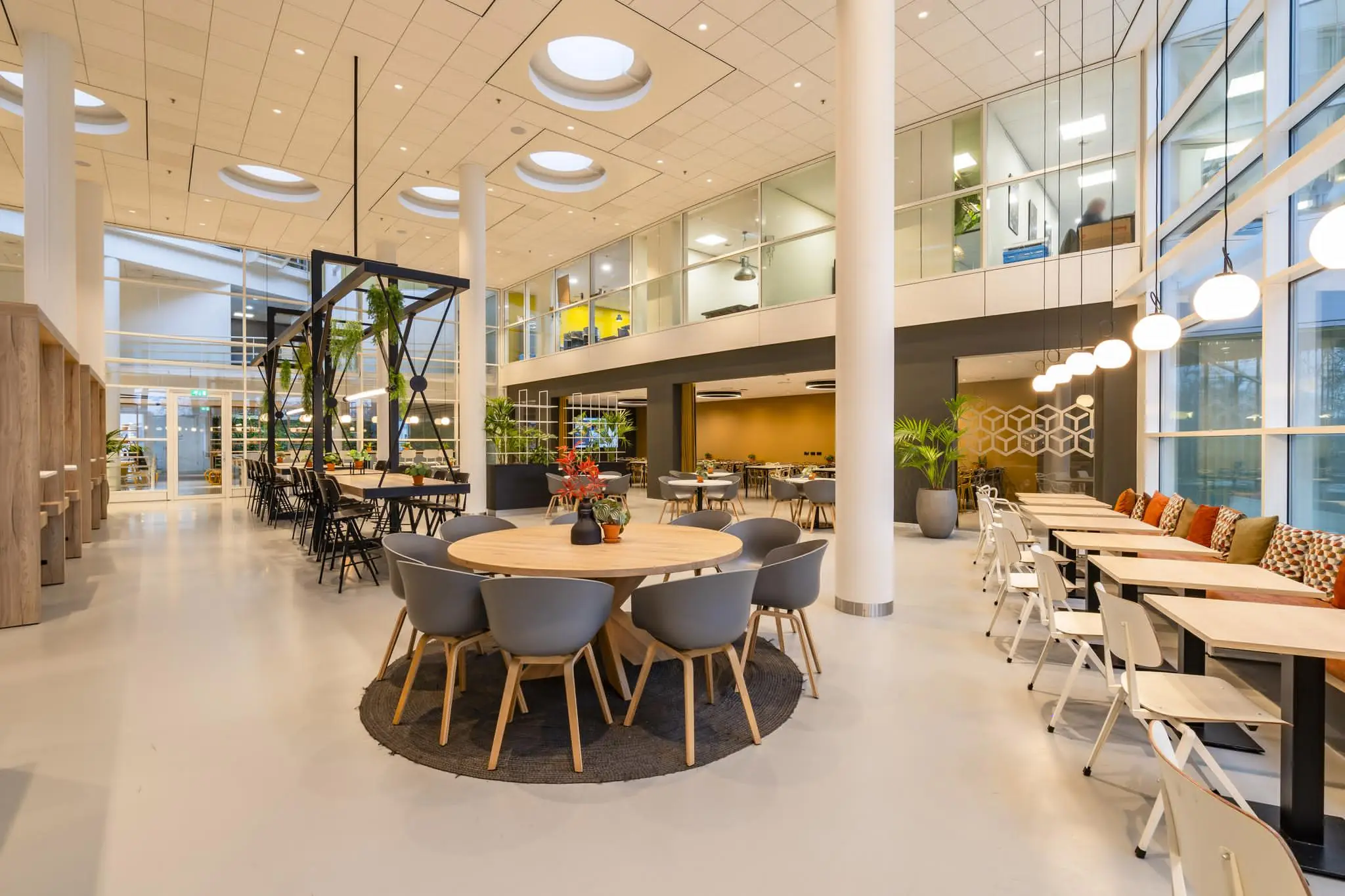Moderne en licht ingerichte bedrijfsruimte aan de Newtonlaan met diverse zitgelegenheden en een open atrium.
