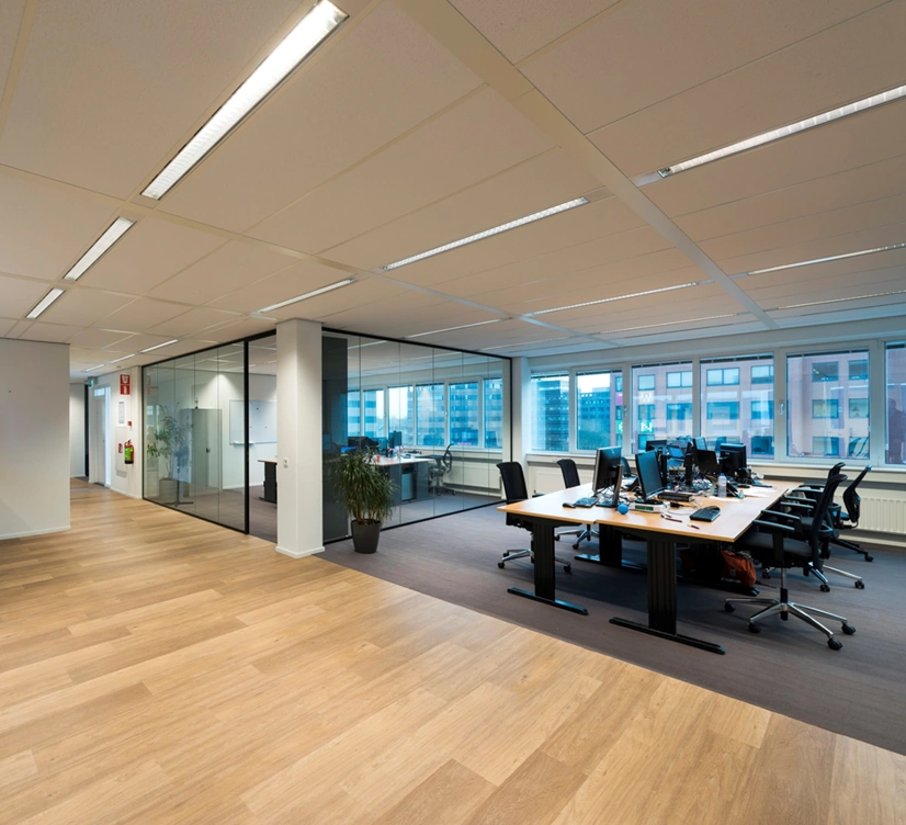 Moderne en ruime kantoorruimte aan de Hogehilweg met werkplekken, glazen vergaderruimtes en uitzicht op omliggende gebouwen.