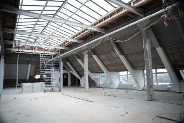 Leegstaande, deels gerenoveerde zolderruimte met metalen draagconstructie en dakramen aan het WG-plein.