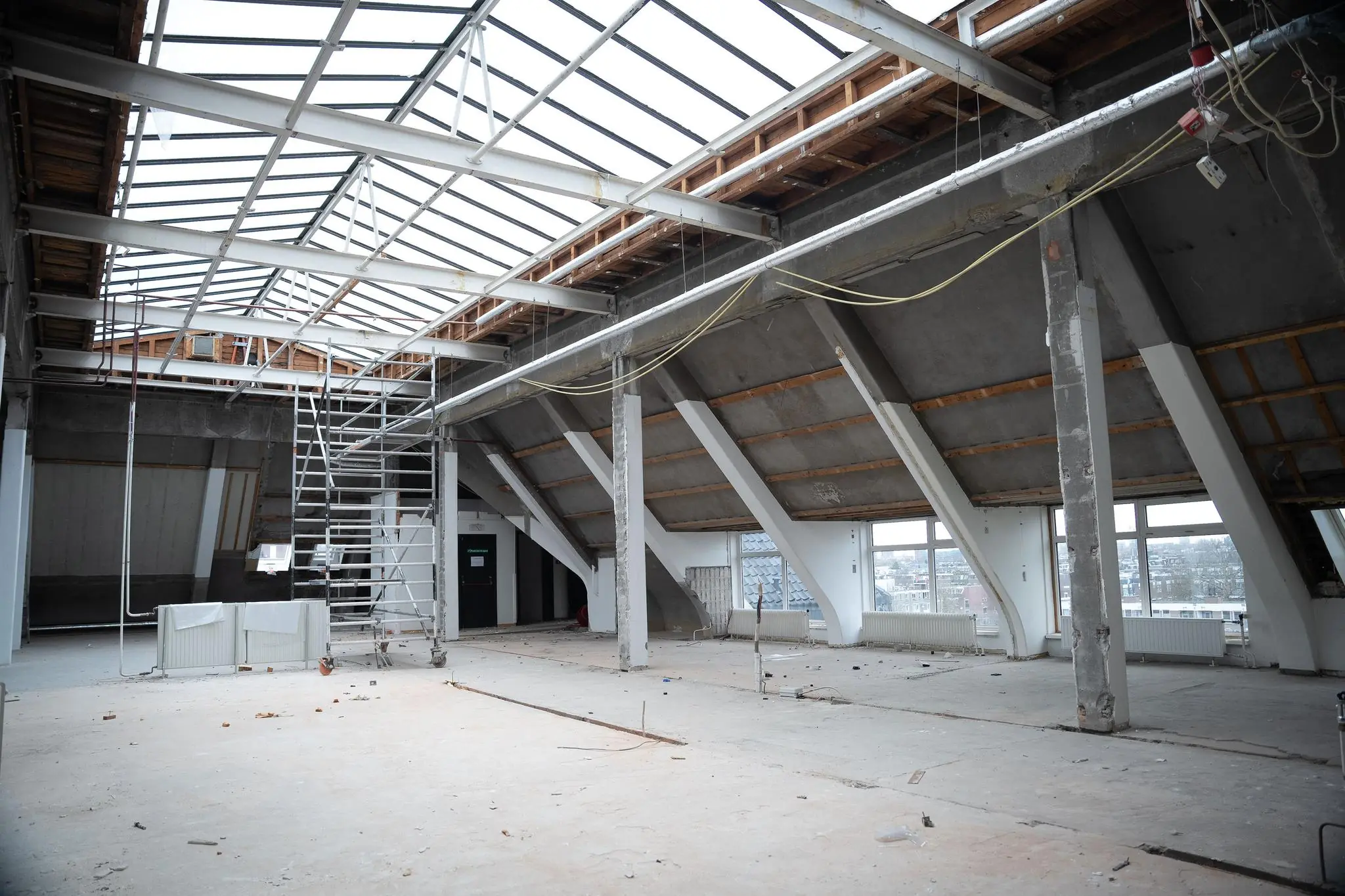 Leegstaande, deels gerenoveerde zolderruimte met metalen draagconstructie en dakramen aan het WG-plein.
