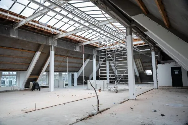 Ruime zolderverdieping op WG-Plein in verbouwing met steiger, schuine dakconstructie en grote dakramen.