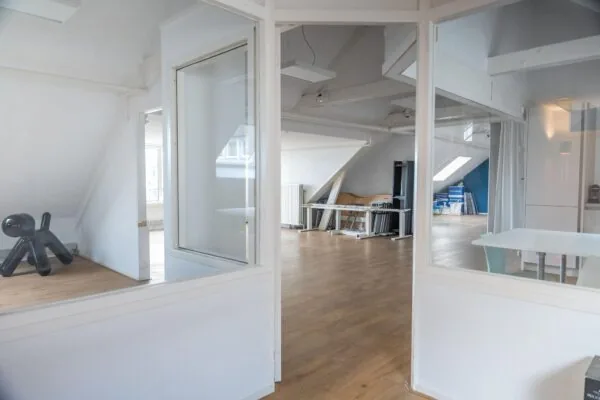 Licht en ruim kantoor op het WG-plein met houten vloer, schuine wanden en moderne inrichting.