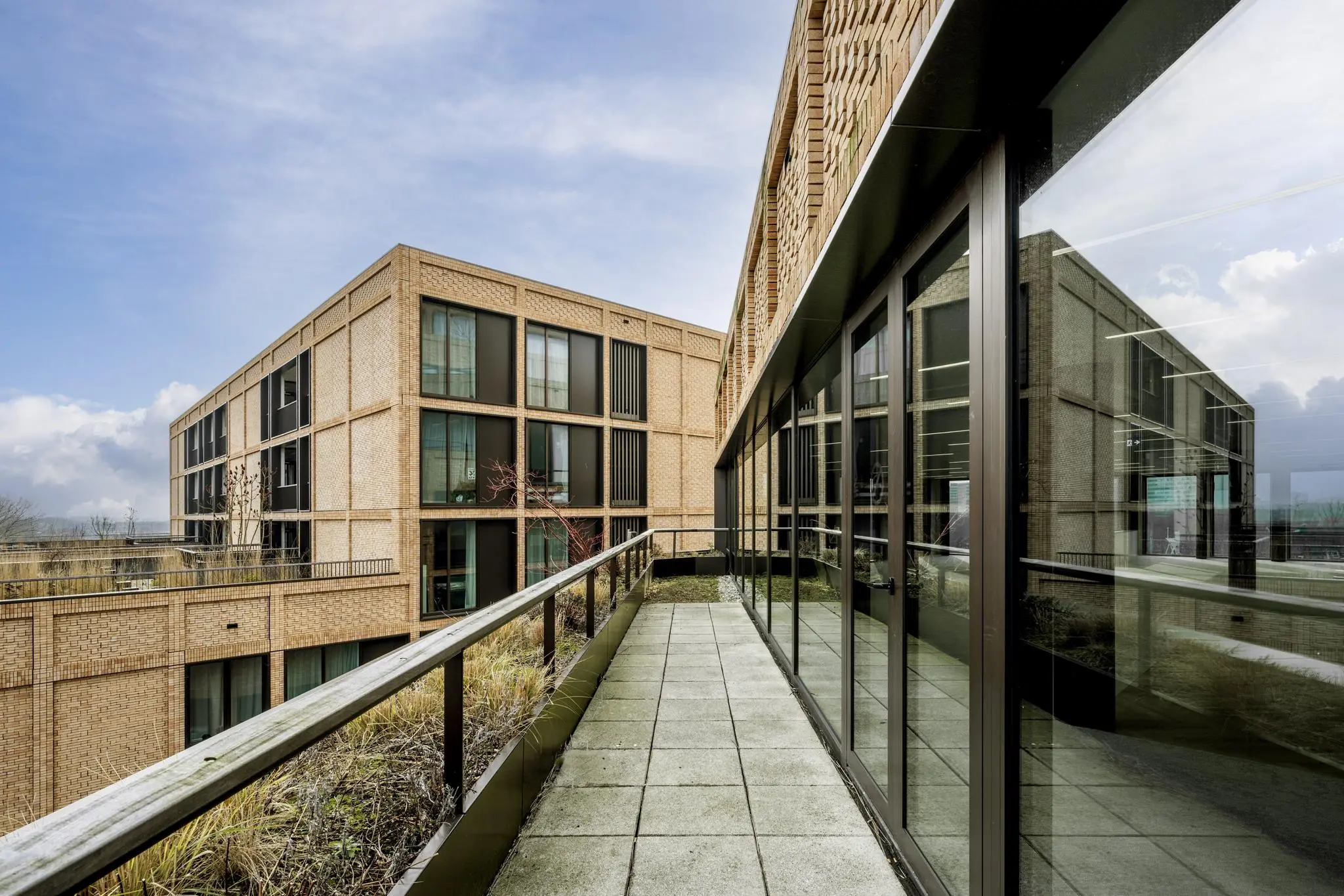 Moderne appartementencomplexen aan de Gelrestraat met een betegeld dakterras en glazen gevels.