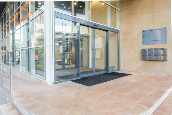 Entree van het kantoorgebouw Spui 174 met automatische schuifdeuren en brievenbussen aan de gevel.