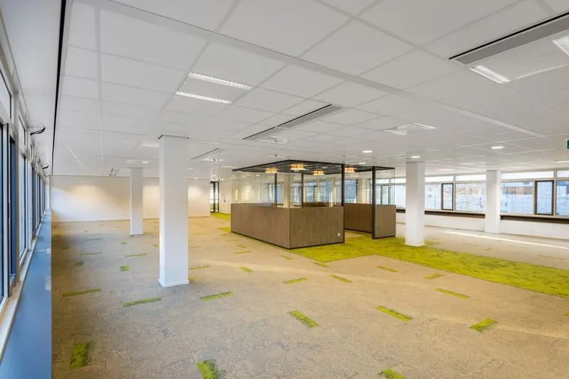 Ruim en licht kantoorgebouw aan het Spui met moderne inrichting en glazen vergaderruimtes.