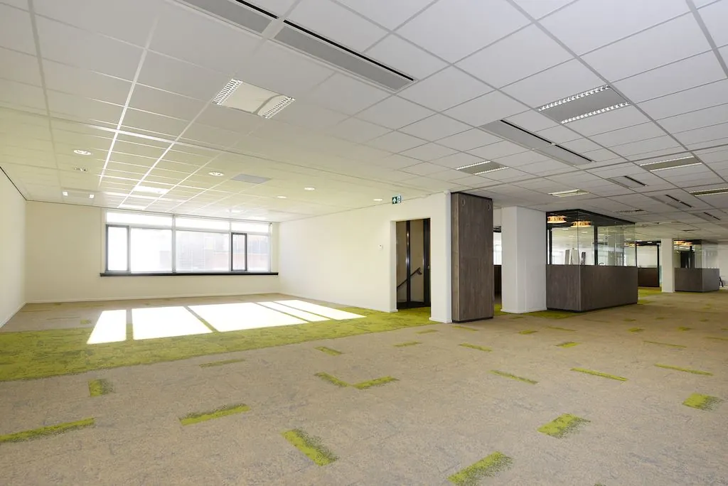 Licht en modern kantoorinterieur aan het Spui met grote ramen en gedeeltelijk open werkruimtes.