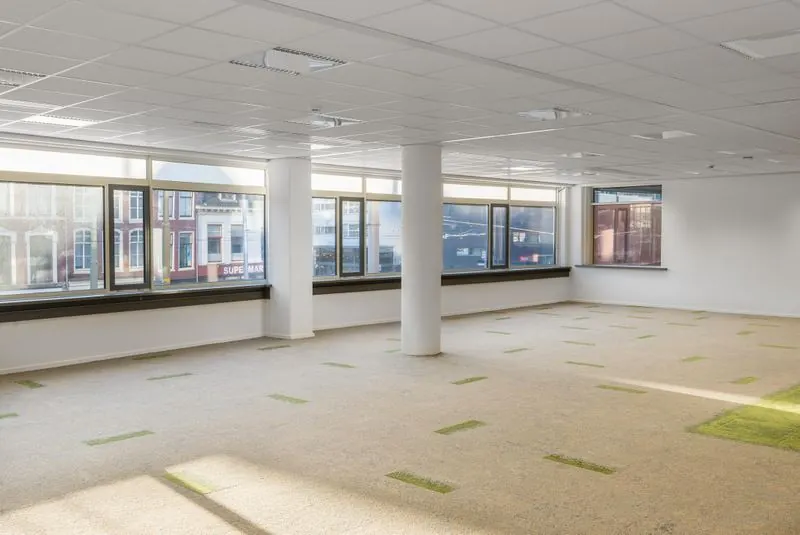 Licht en modern leeg kantoorpand aan het Spui met grote ramen en uitzicht op de straat.