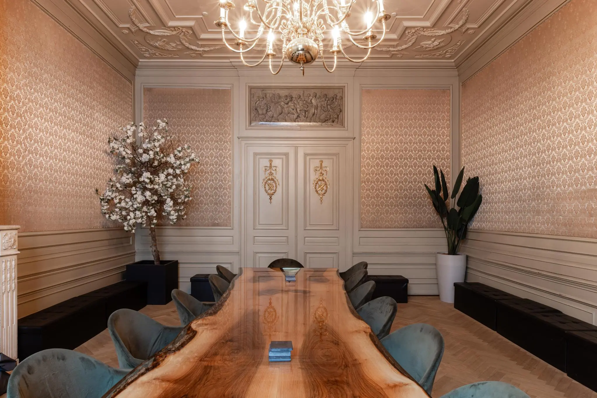 Luxe vergaderruimte aan het Rokin met een glanzende houten tafel, fluwelen stoelen en klassieke wand- en plafonddecoraties.