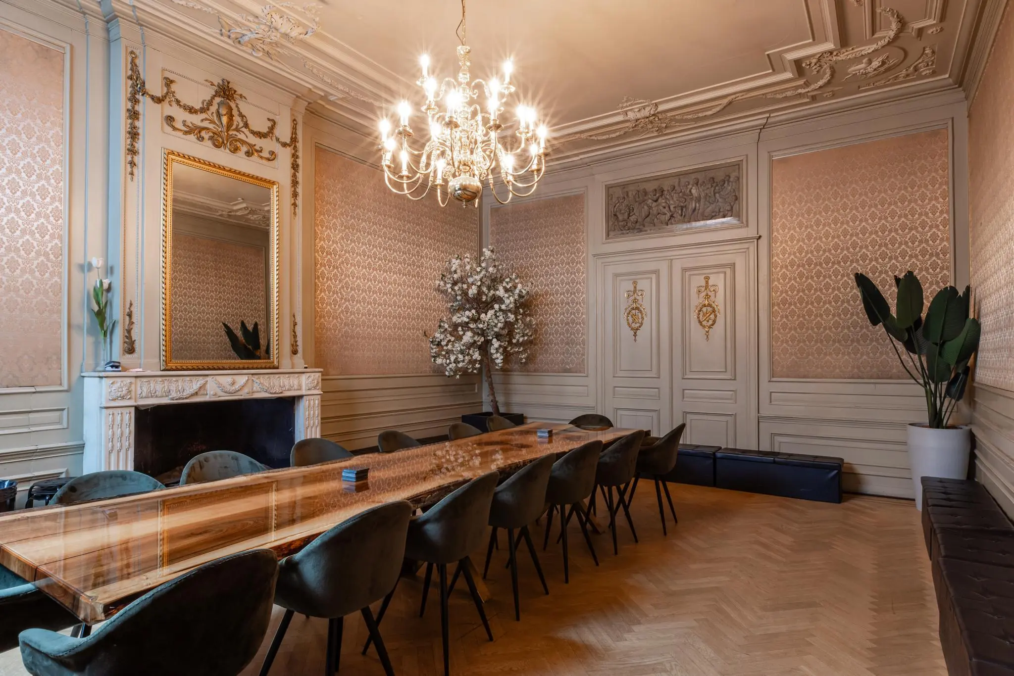 Sfeervolle vergaderruimte aan het Rokin met een lange houten tafel, fluwelen stoelen, sierplafond en klassieke wanddecoratie.