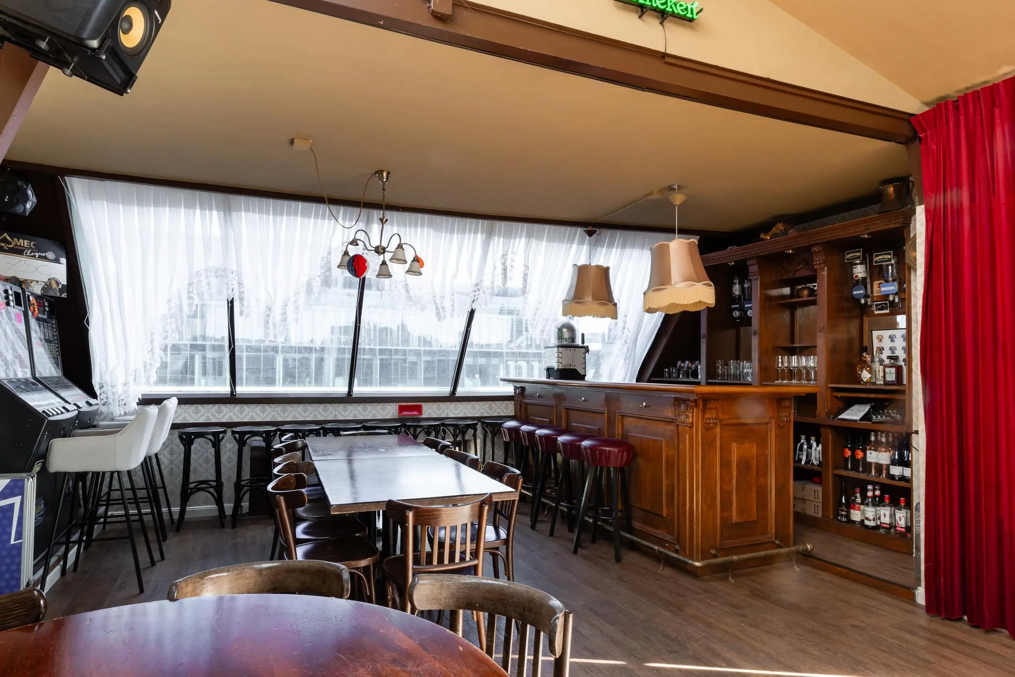 Knusse bar aan het Rokin met houten interieur, barkrukken, flessen drank en een klassieke sfeer.