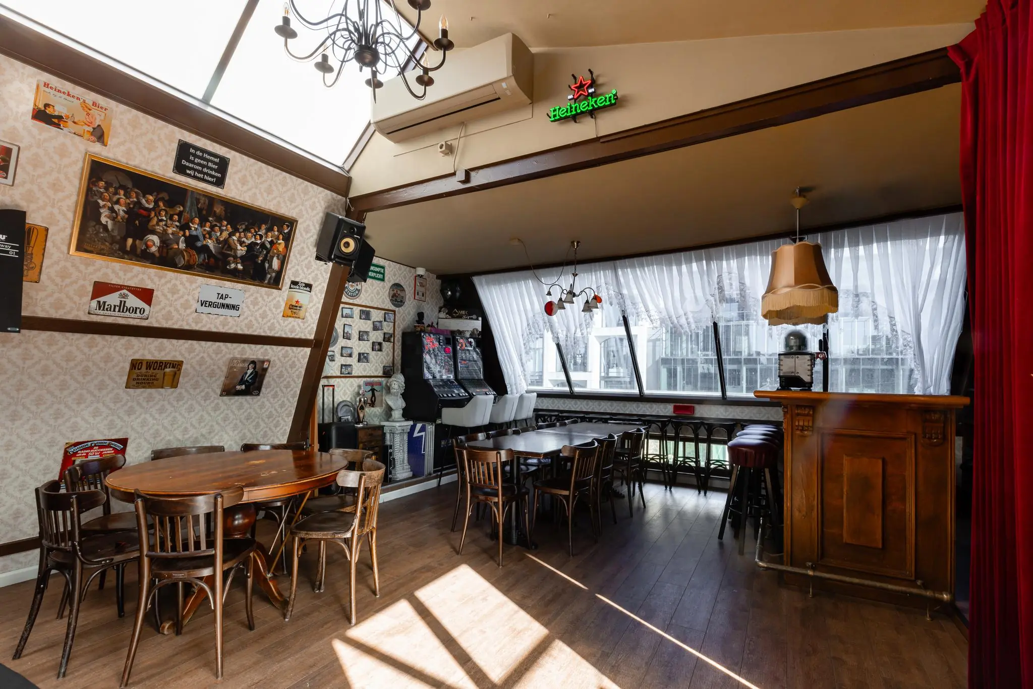 Knusse bruine kroeg aan het Rokin met houten meubilair, vintage wanddecoratie en een klassieke bar.