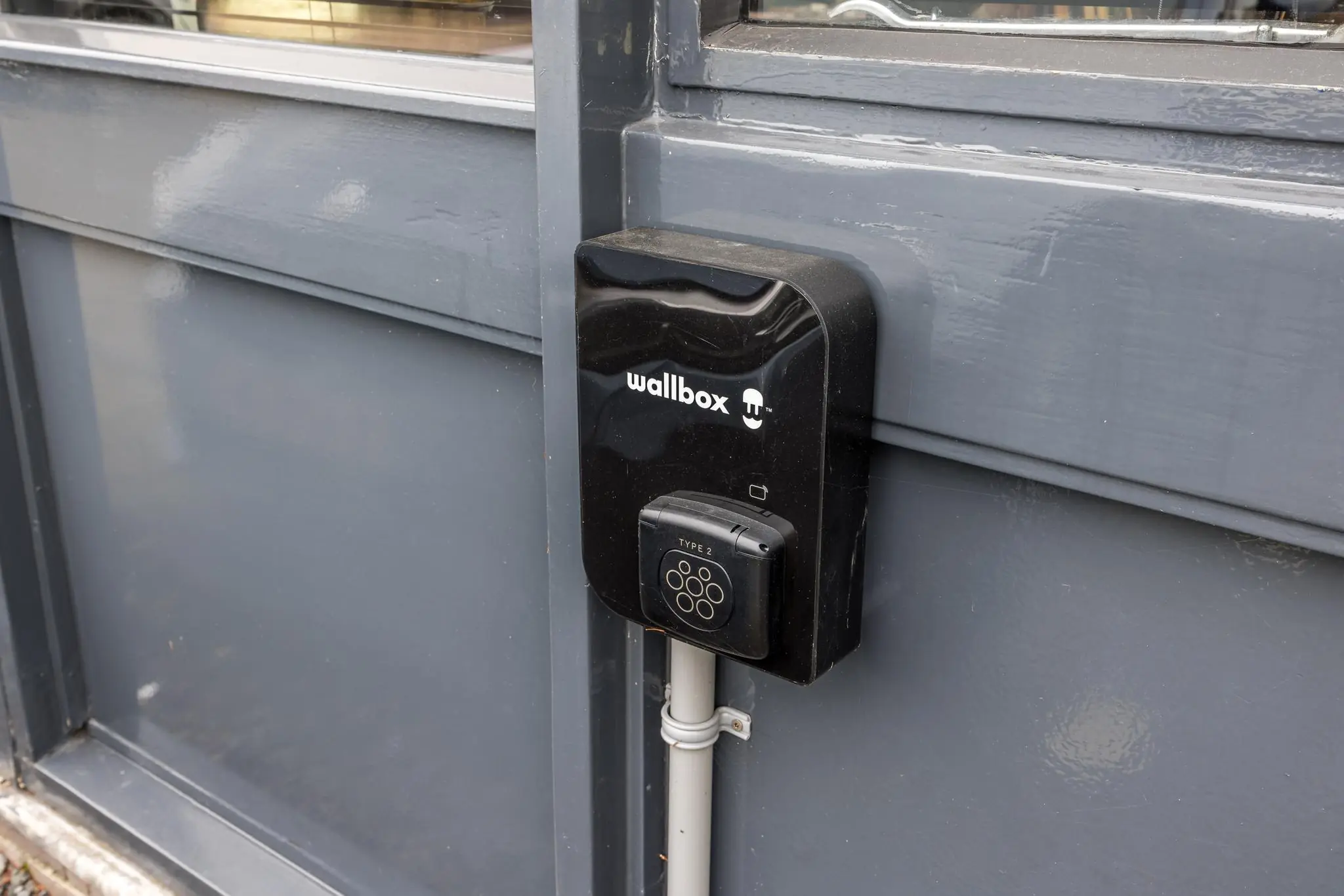 Wandgemonteerde Wallbox Type 2-laadpaal aan een grijze gevel op de Industrieweg.