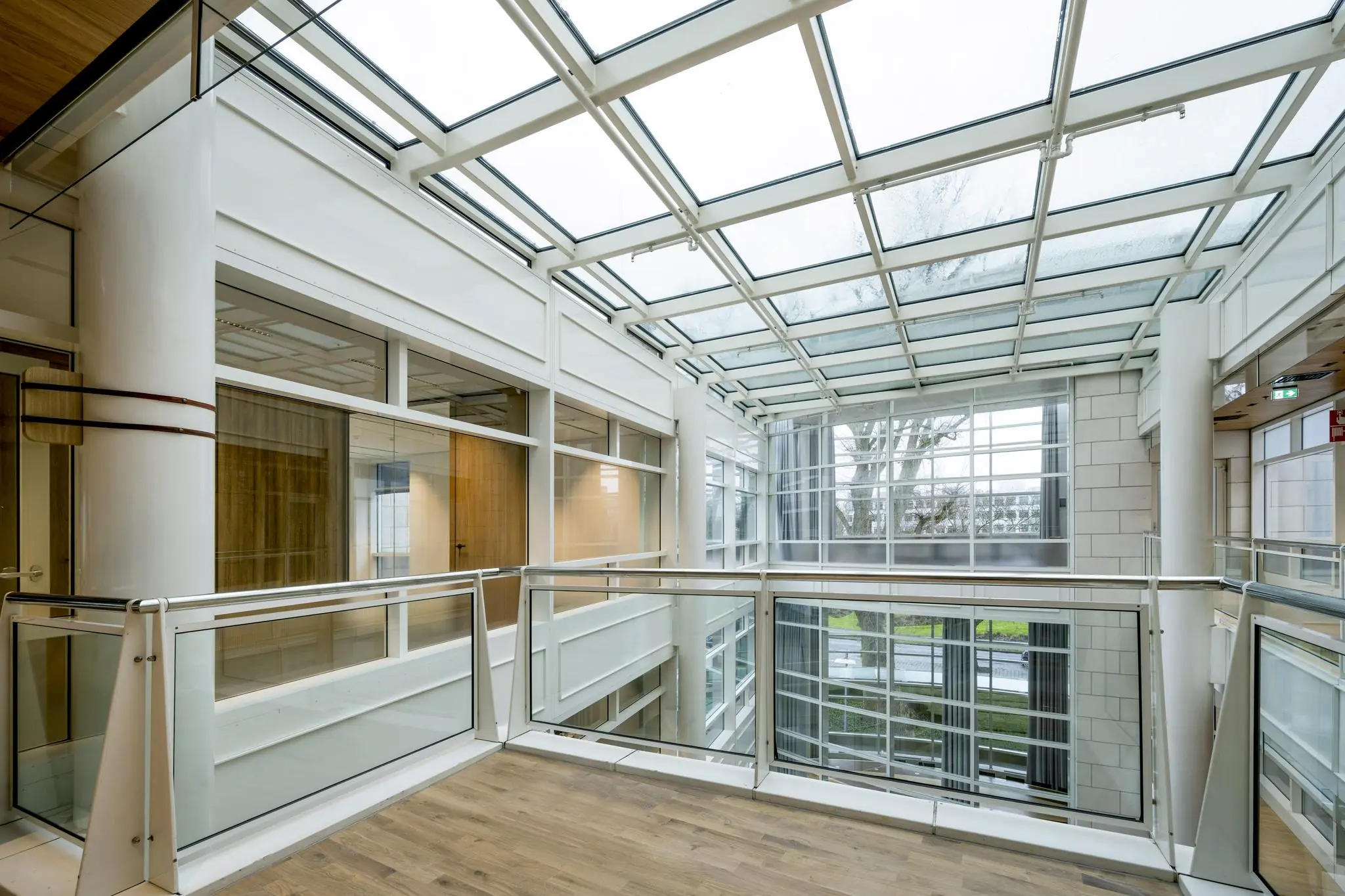 Licht atrium met glazen dak en moderne kantoorarchitectuur aan de Apollolaan.