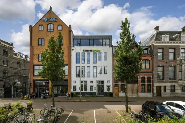 Voorgevels van bedrijfsgebouwen aan de De Ruijterkade in Amsterdam, met onder andere SMC en LimoenGroen.