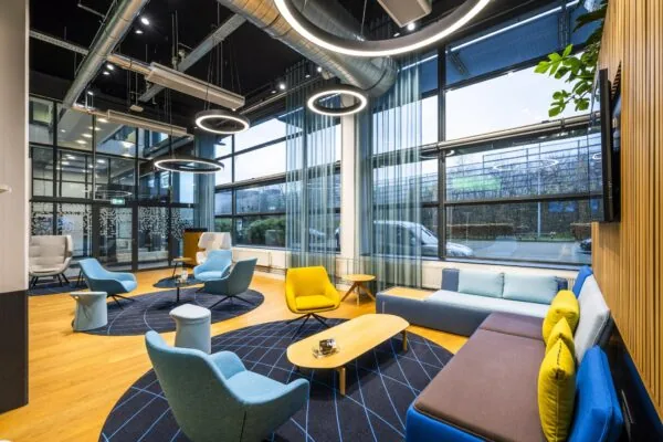 Modern ingerichte wachtruimte met kleurrijke zitmeubels en grote ramen aan de Kabelweg.