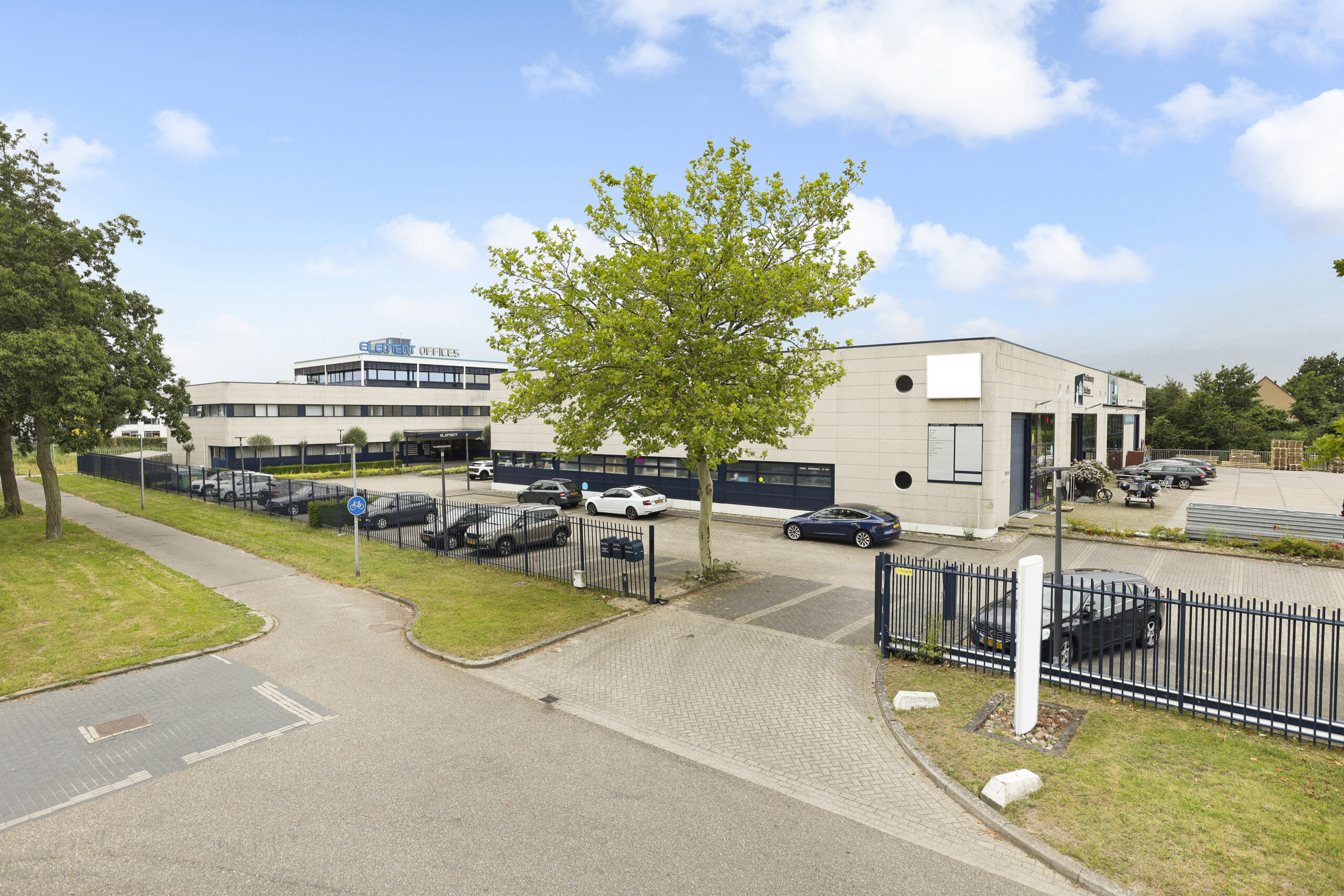 Buitenaanzicht van Element Offices aan de Markerkant 13 10 in Almere met parkeerplaats en bomen.