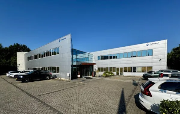 Modern kantoorpand van Coloplast aan de Softwareweg met geparkeerde auto's op de voorgrond.