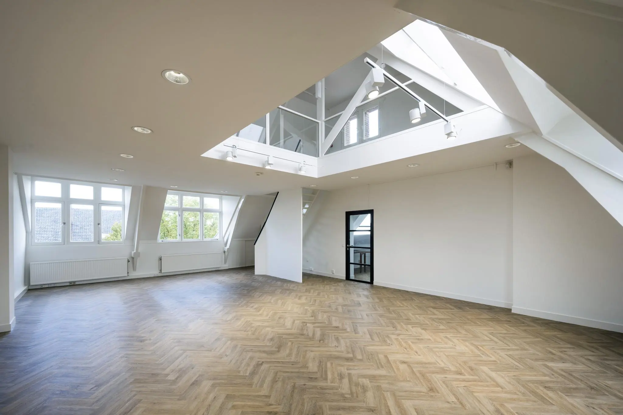 Licht en ruim modern interieur op Emmaplein met visgraatvloer en glazen vide.