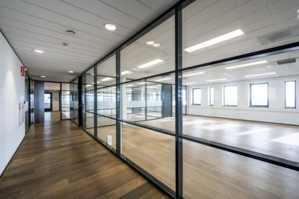 Moderne kantoorruimte aan de Sijsjesbergweg met glazen scheidingswanden en houten vloer.