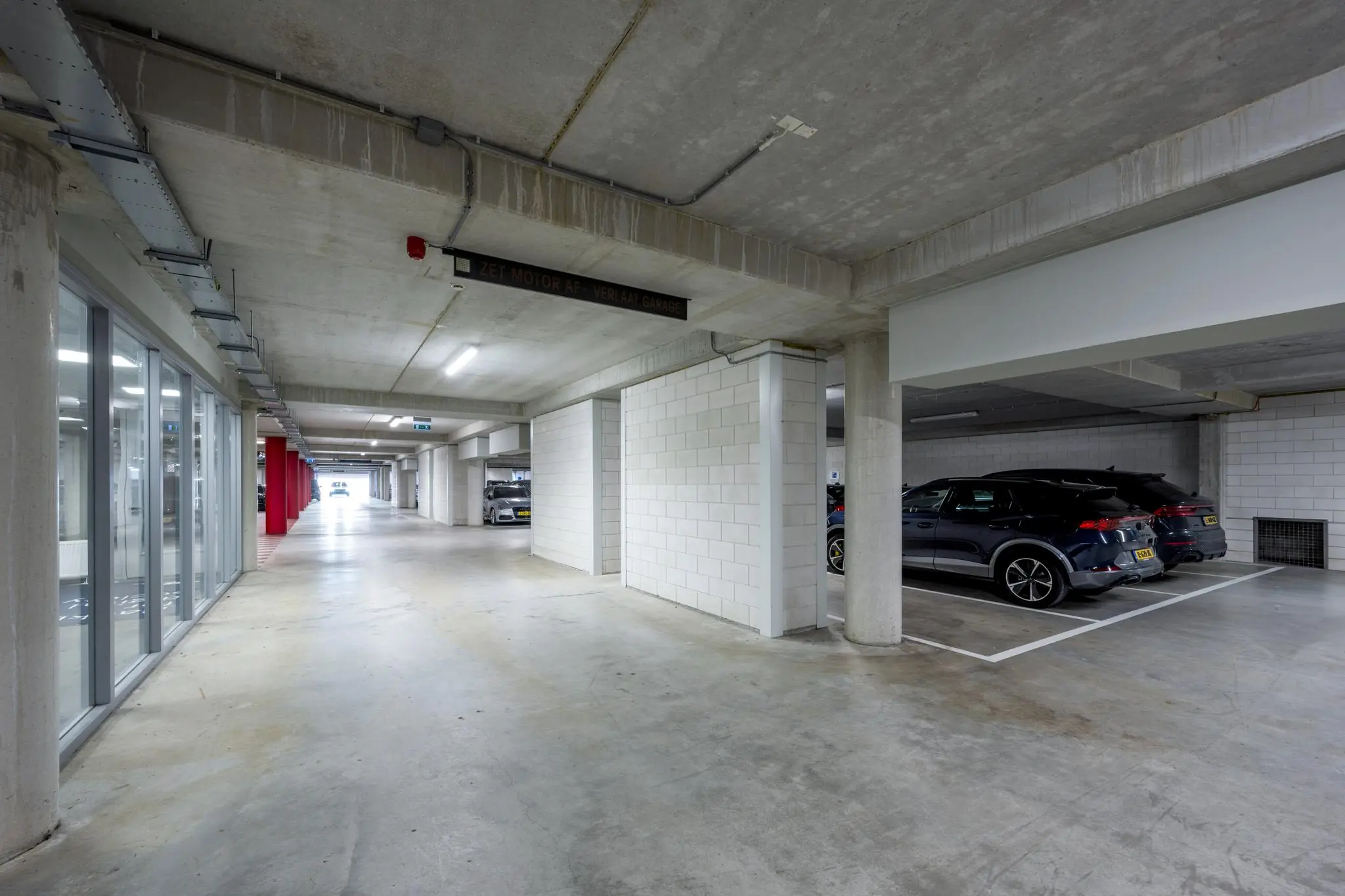 Ondergrondse parkeergarage aan de Sijsjesbergweg met geparkeerde auto's en betonnen muren.