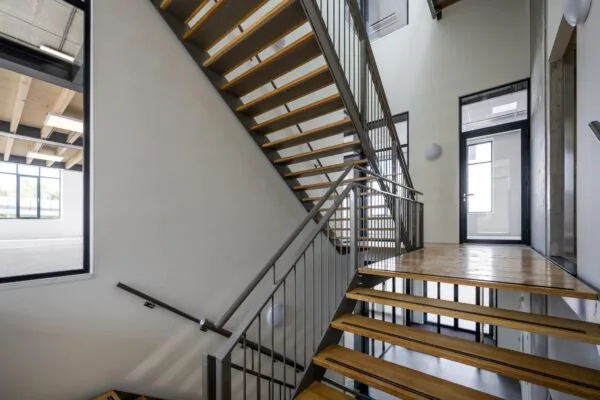 Moderne houten trap met metalen leuning in een licht trappenhuis aan de Nicolaas Tetterodestraat.