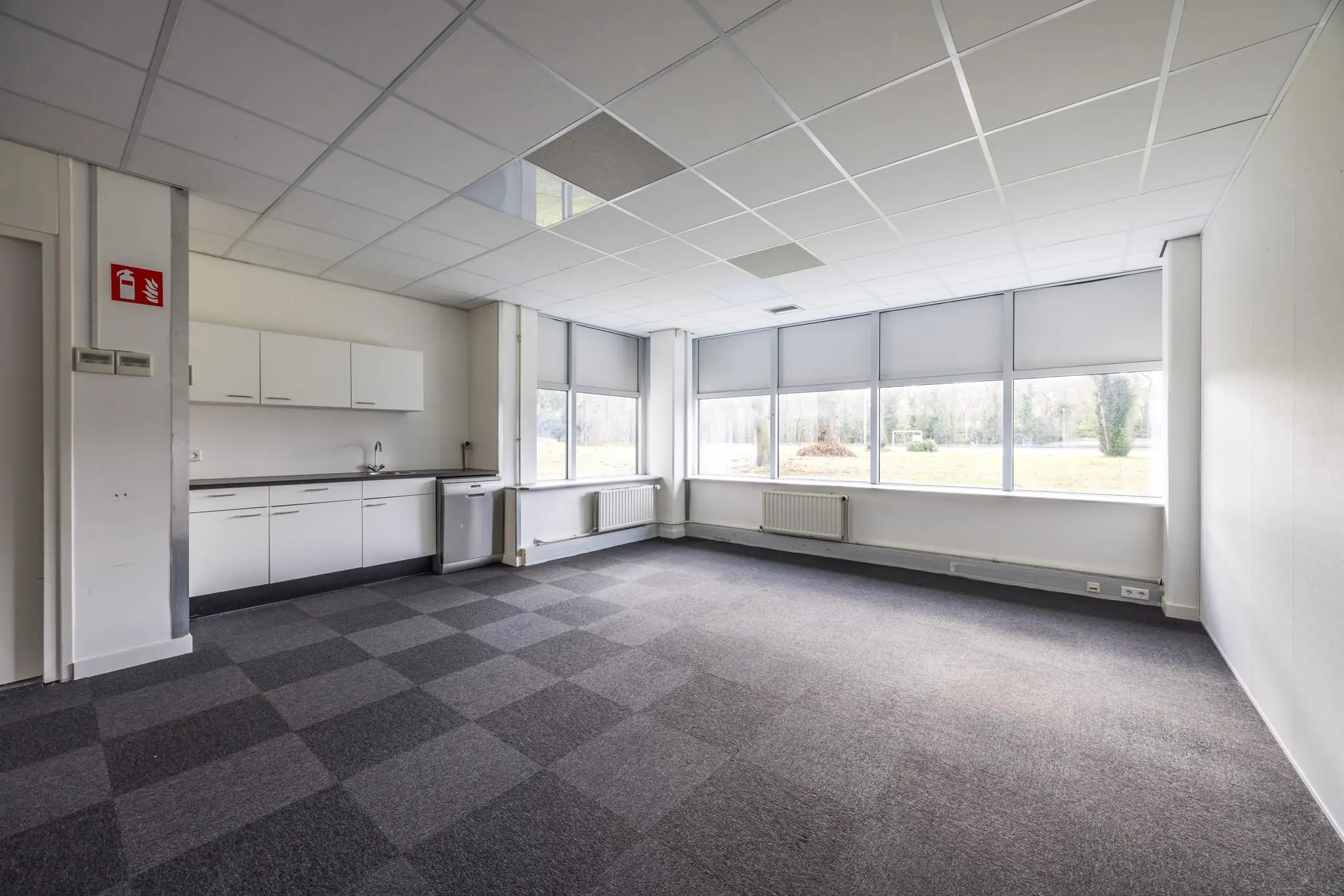 Leeg kantoorruimte met pantry en grote ramen aan de Dolderseweg.