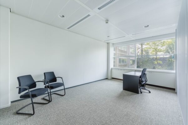 Licht en minimalistisch kantoor aan de Laarderhoogtweg met bureau, bureaustoel en twee bezoekersstoelen.